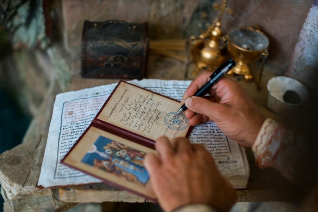 A person writes in an antique diary, surrounded by ancient artifacts and sacred texts.